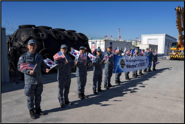ROK Navy sailors wave flags to welcome Los Angeles class fast attack submarine USS Columbia to South Korea’s Busan Naval Base on November 18, 2024