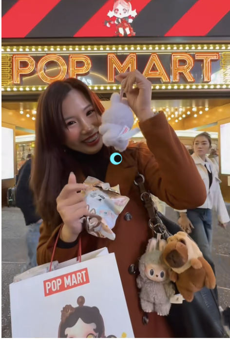 A social media poster shows off a newly purchased Labubu doll in front of a Pop Mart store in Taiwan